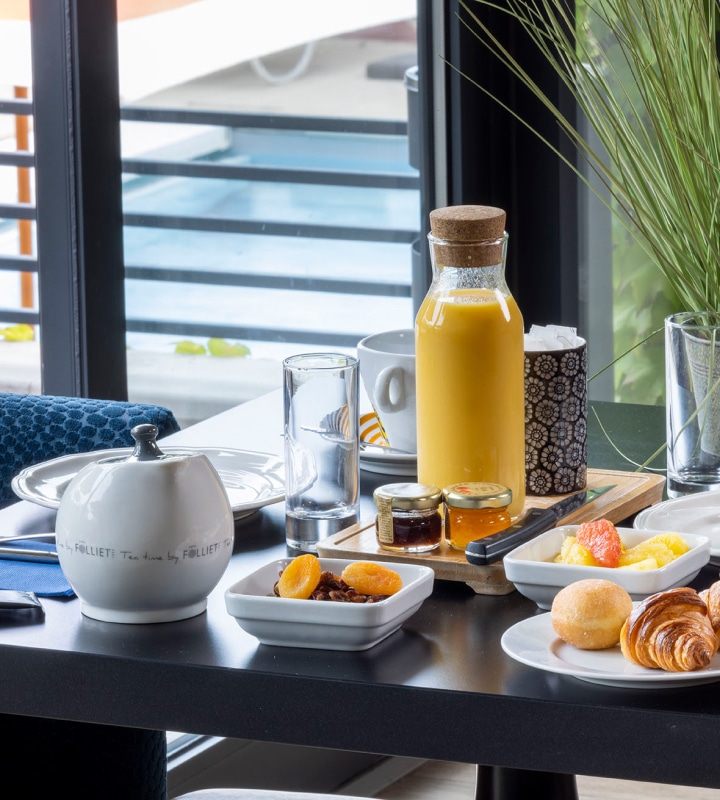Un petit-déjeuner savoureux servi dans un cadre élégant au Lou Paradou Hotel, mettant en avant des produits frais tels que des jus de fruits, des confitures artisanales, et une sélection de viennoiseries. La table est soigneusement dressée, offrant une vue sur la piscine, créant une atmosphère relaxante et accueillante, idéale pour commencer la journée dans ce refuge de bien-être en Provence. Le service attentionné du personnel contribue à une expérience de séjour mémorable,